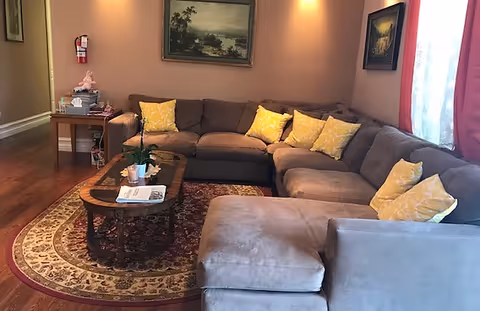 A cozy living room with a large sectional sofa, decorative pillows, and a coffee table.