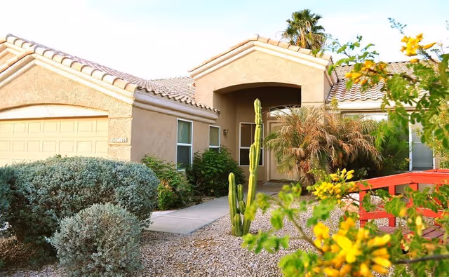 Front exterior view of Medina House Assisted Living Home with desert landscaping