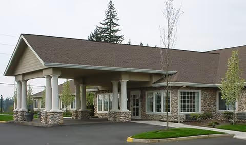 Exterior view of a senior care center with a covered entrance and stone columns.
