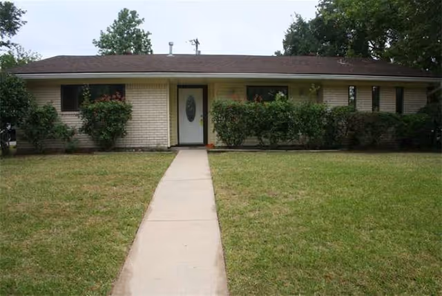 Single-story brick senior living facility exterior with a central walkway to the front door.