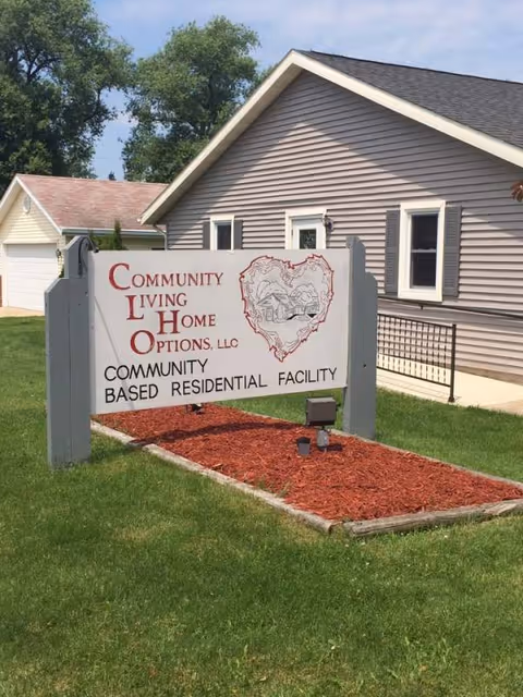 Exterior view of a residential facility with a large sign reading Community Living Home Options.