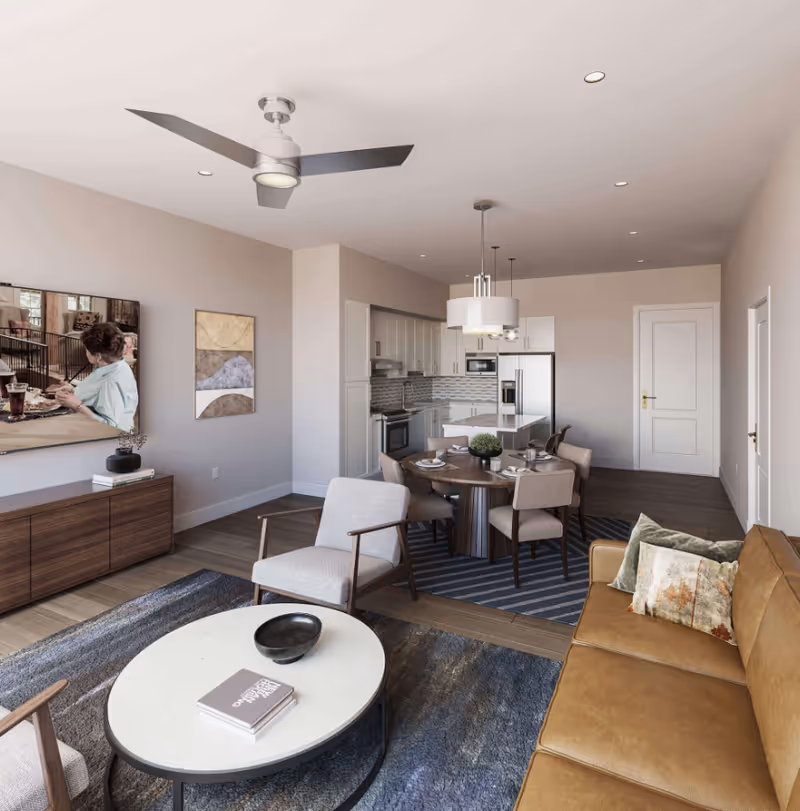 A stylish living area featuring a brown leather couch, dining table, and modern kitchen.