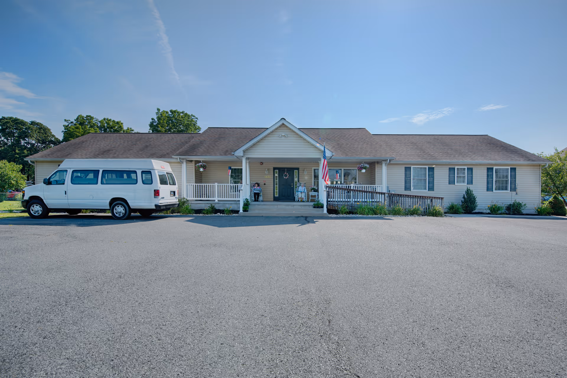 Single story assisted living facility exterior with a white van parked at the entrance.