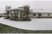 Front exterior of Pioneer Place Assisted Living with a covered entrance and snow-covered driveway.