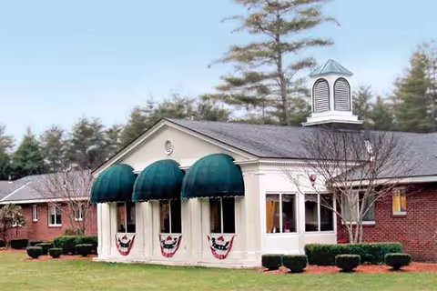 Quabbin Valley Healthcare building front with green awnings and patriotic bunting.