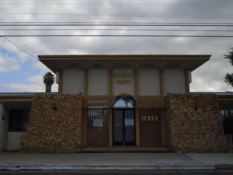 Front view of Imperial Crest Healthcare Center with stone facade and arched entrance.