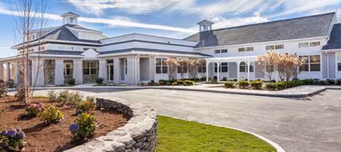 Exterior view of Avita of Newburyport, a modern senior living facility with landscaped entrance.