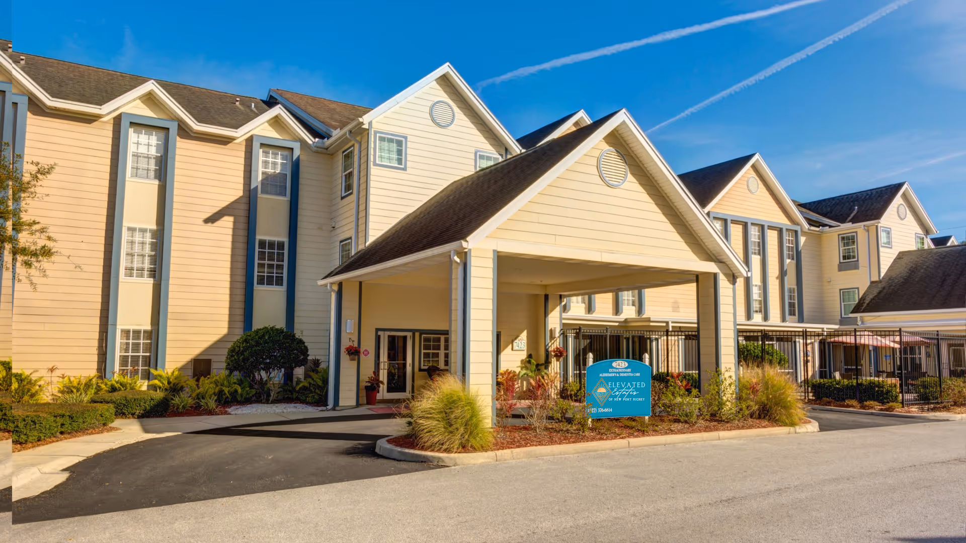Exterior view of Elevated Estates senior living community with a covered entrance and landscaping.