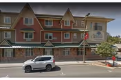 Front exterior view of Courtyard Assisted Living building along a street.