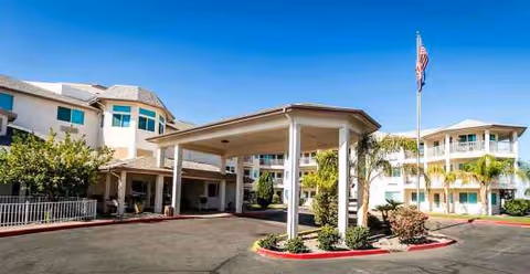 Exterior view of Desert Rose Retirement Community with a covered driveway and American flag.