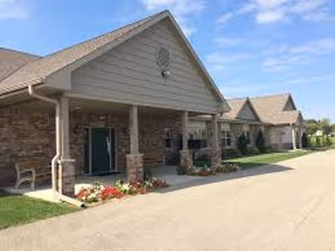Exterior view of Hamilton Park Place Assisted Living with brick porch and landscaped entrance.