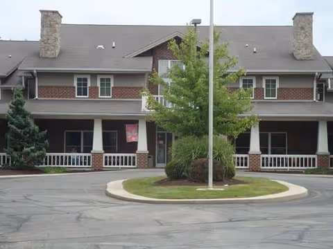 Two-story brick senior living facility with a circular driveway and front entry.