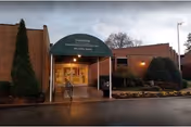 Exterior of Glenburnie Rehabilitation and Nursing Center with green canopy entrance and shrub landscaping.