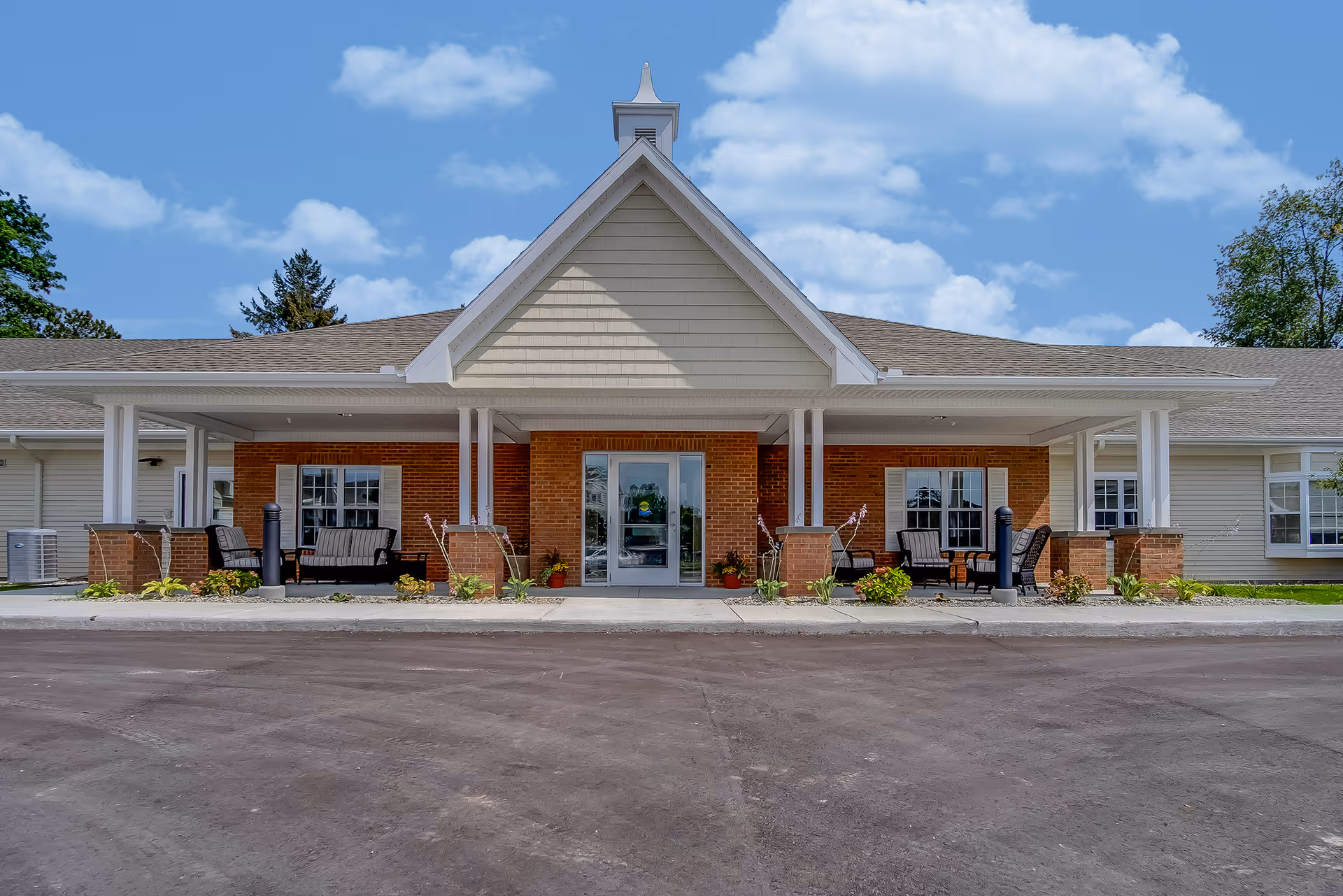 Front view of Grandhaven Living Center building with a covered entrance and outdoor seating.