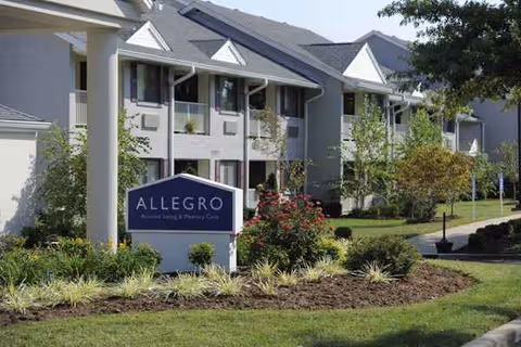 Exterior view of Willow Creek Senior Living building with sign and landscaped entrance.