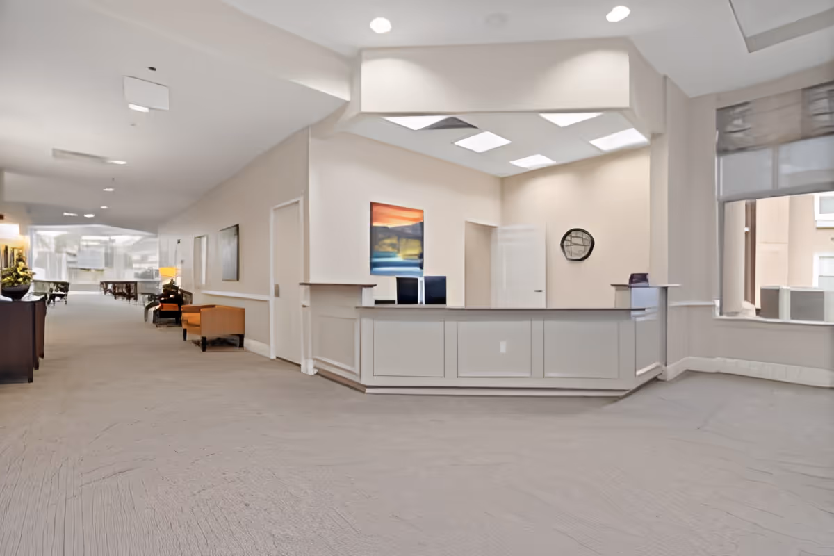 Spacious reception desk and lobby area with seating, artwork, and large windows.