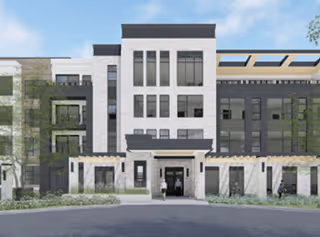 Front exterior view of a modern multi-story apartment building with large windows and a central entrance. Two people are walking near the entrance, and there are trees and landscaping around the building.