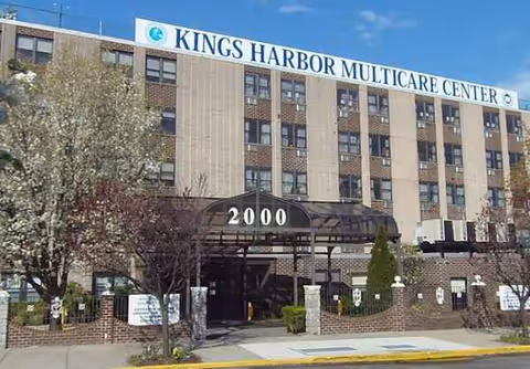 Front view of Kings Harbor Multicare Center with entrance canopy and address 2000