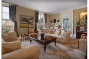 Cozy living room in a senior care facility with beige sofas and a wood coffee table.