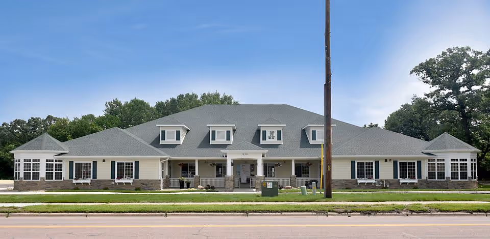 Front exterior of Birchwood Cottages, a low-rise symmetrical building with dormer windows, a central covered entrance, and a manicured lawn.