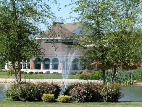 Front exterior of Jefferson's Ferry Lifecare Retirement with a fountain, pond, and trees.