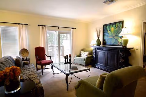 Cozy living room at Longhorn Village with sofa, armchairs, coffee table, and a dark sideboard.