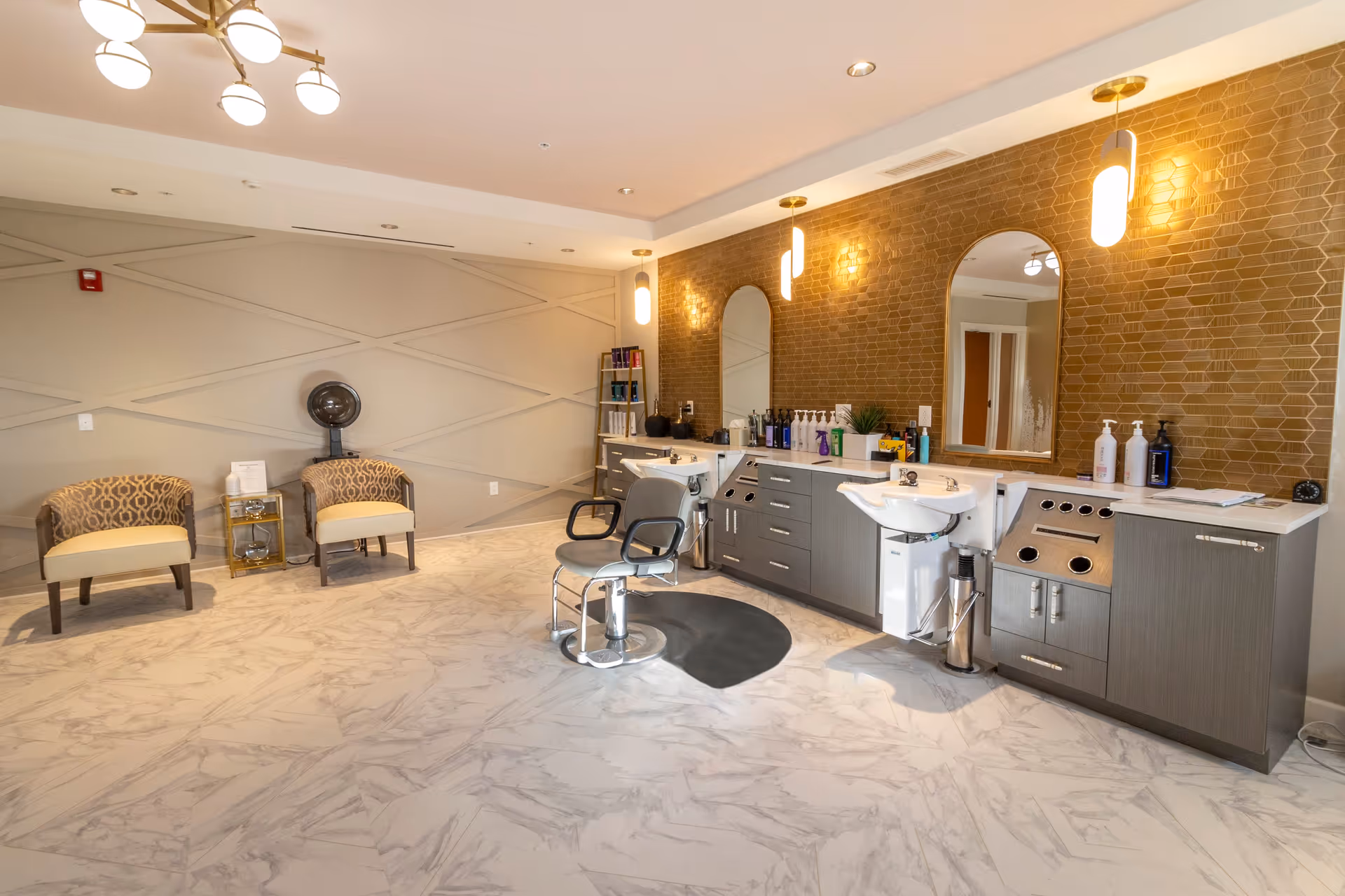 Bright modern salon area with styling chairs, wash basins, mirrors, and seating in a senior living facility.