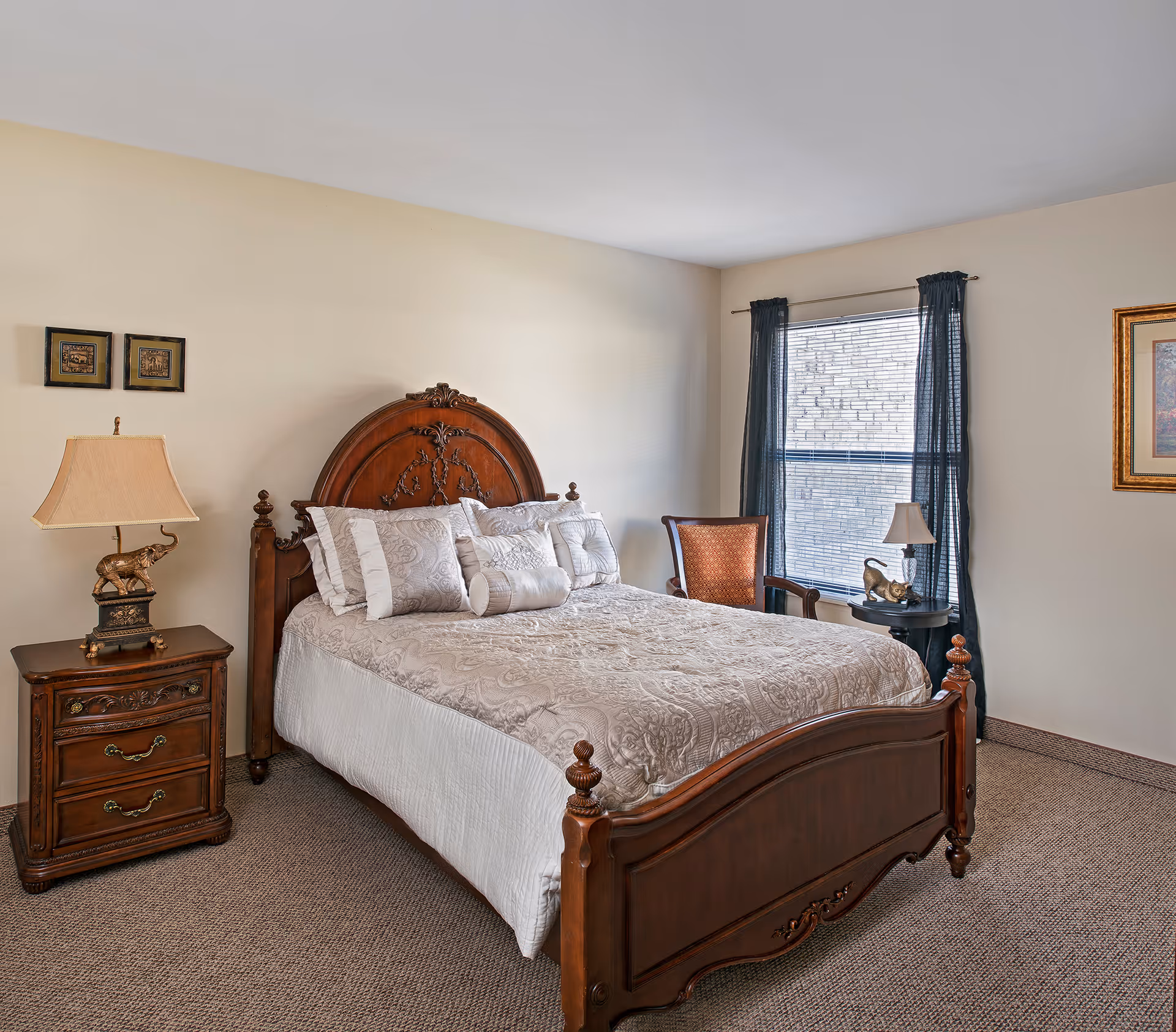 A neatly arranged bedroom with an ornate wooden bed, nightstands, lamps, and a window with dark curtains.