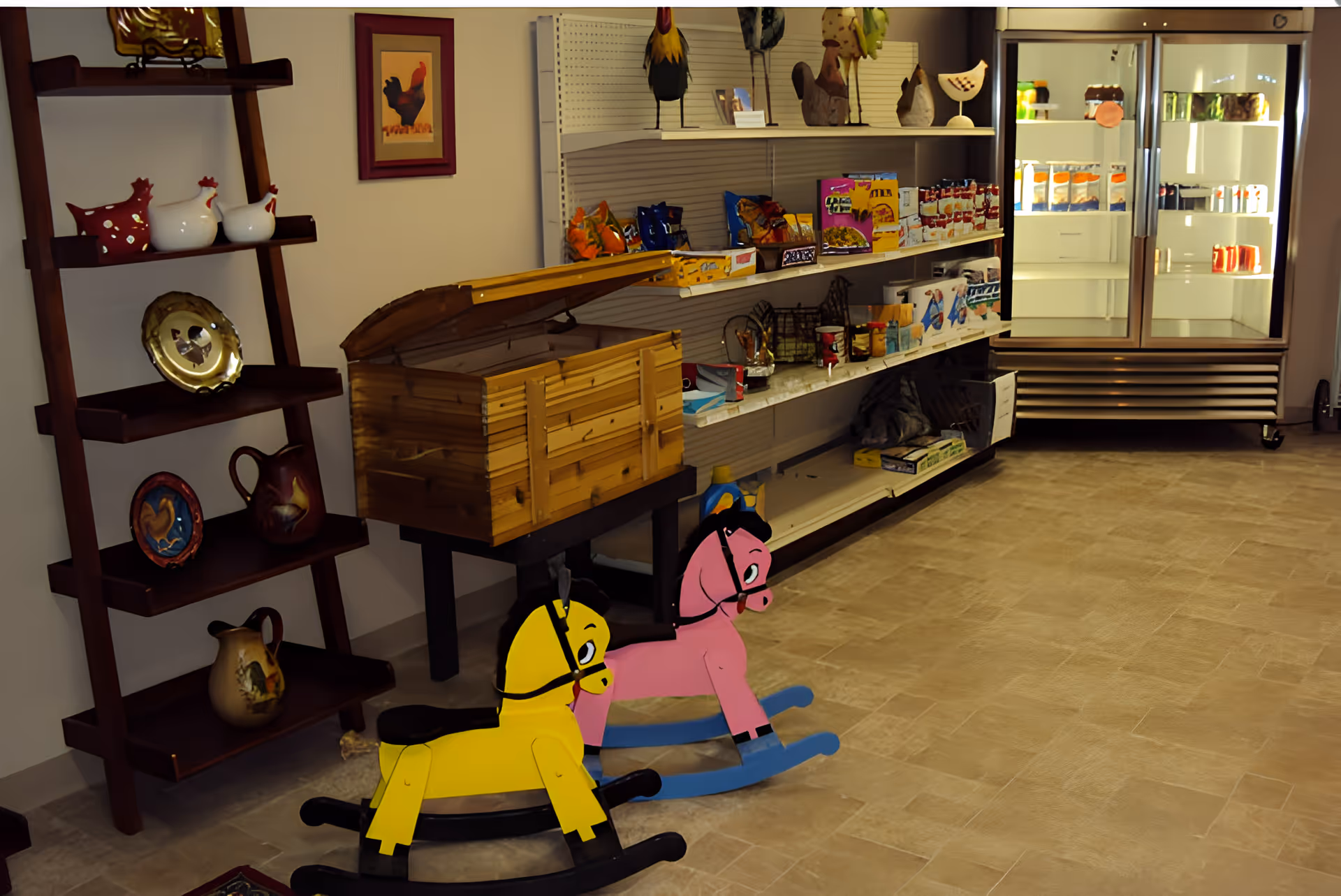 Interior room with shelves displaying decorative items including ceramic chickens and plates, a wooden chest on a stand, two colorful wooden rocking horses on the floor, and a refrigerated display case filled with various packaged goods.