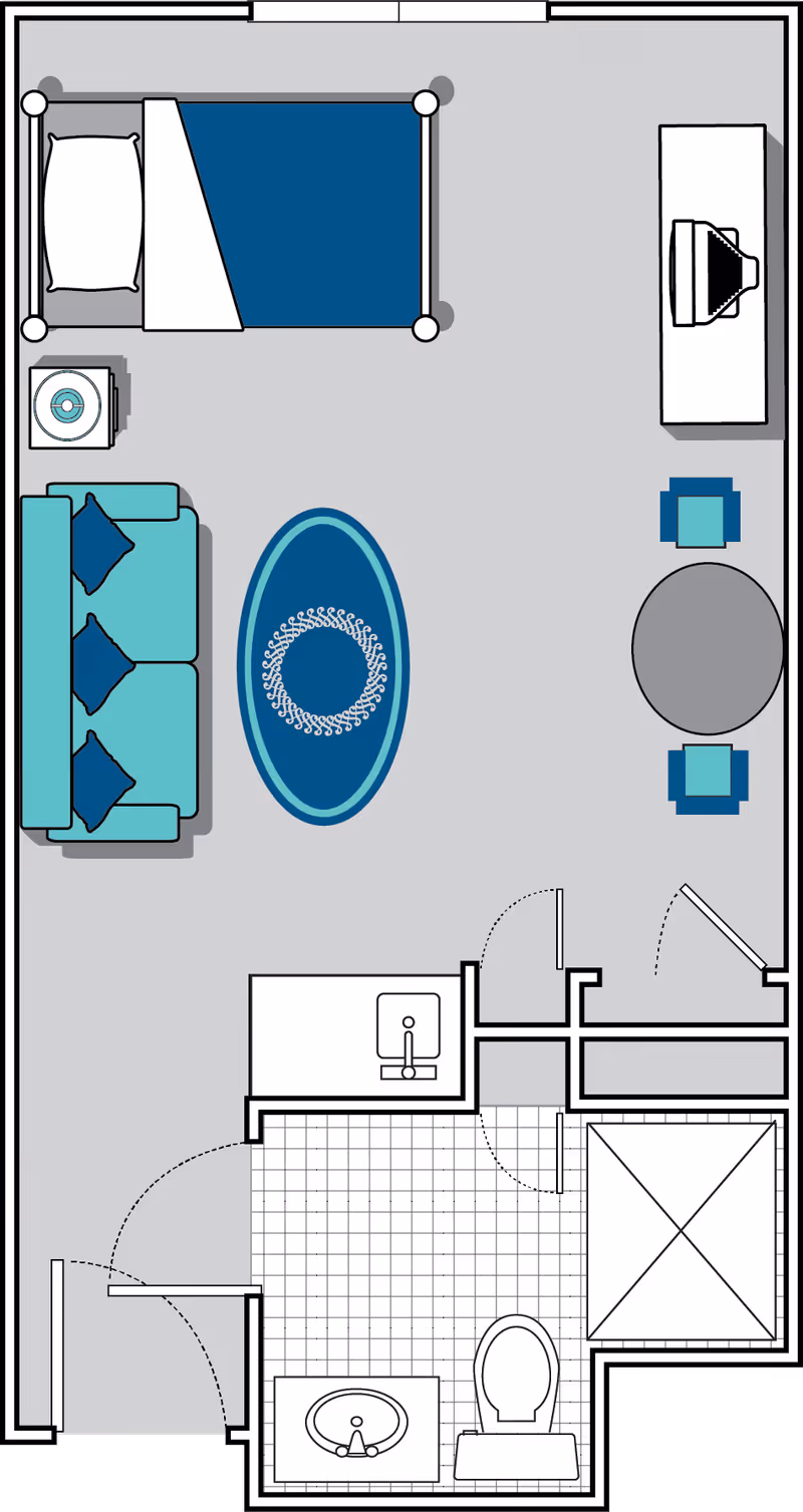 Floor plan of a senior living facility room at Oaks at Charleston showing a bedroom area with a bed and nightstand, a living area with a sofa and coffee table, a dining area with a round table and two chairs, and a bathroom with a sink, toilet, and shower.