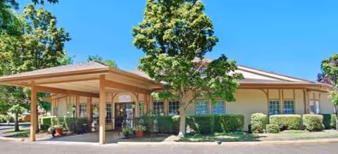 Exterior view of Brookdale Grand Prairie with a covered entrance and manicured landscaping.