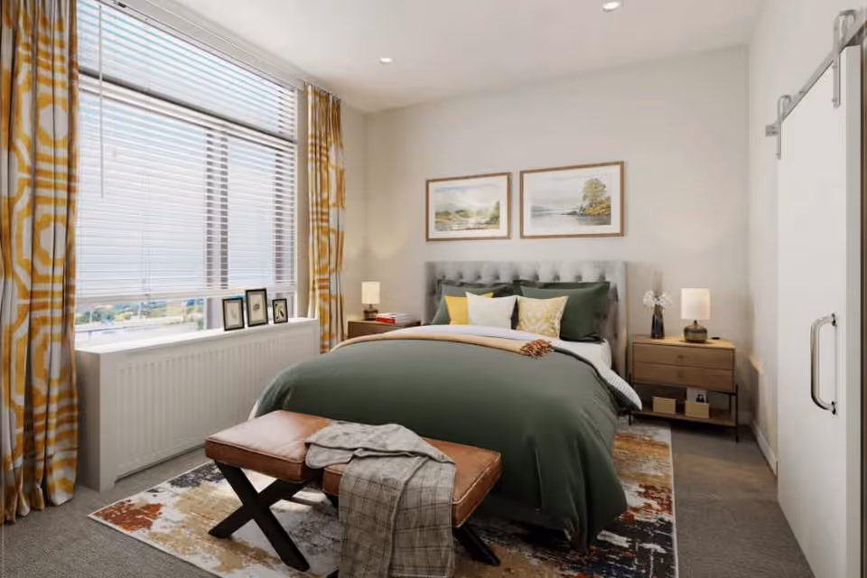 Bright bedroom with a green-covered bed, tufted headboard, bedside tables and a window with yellow patterned curtains.