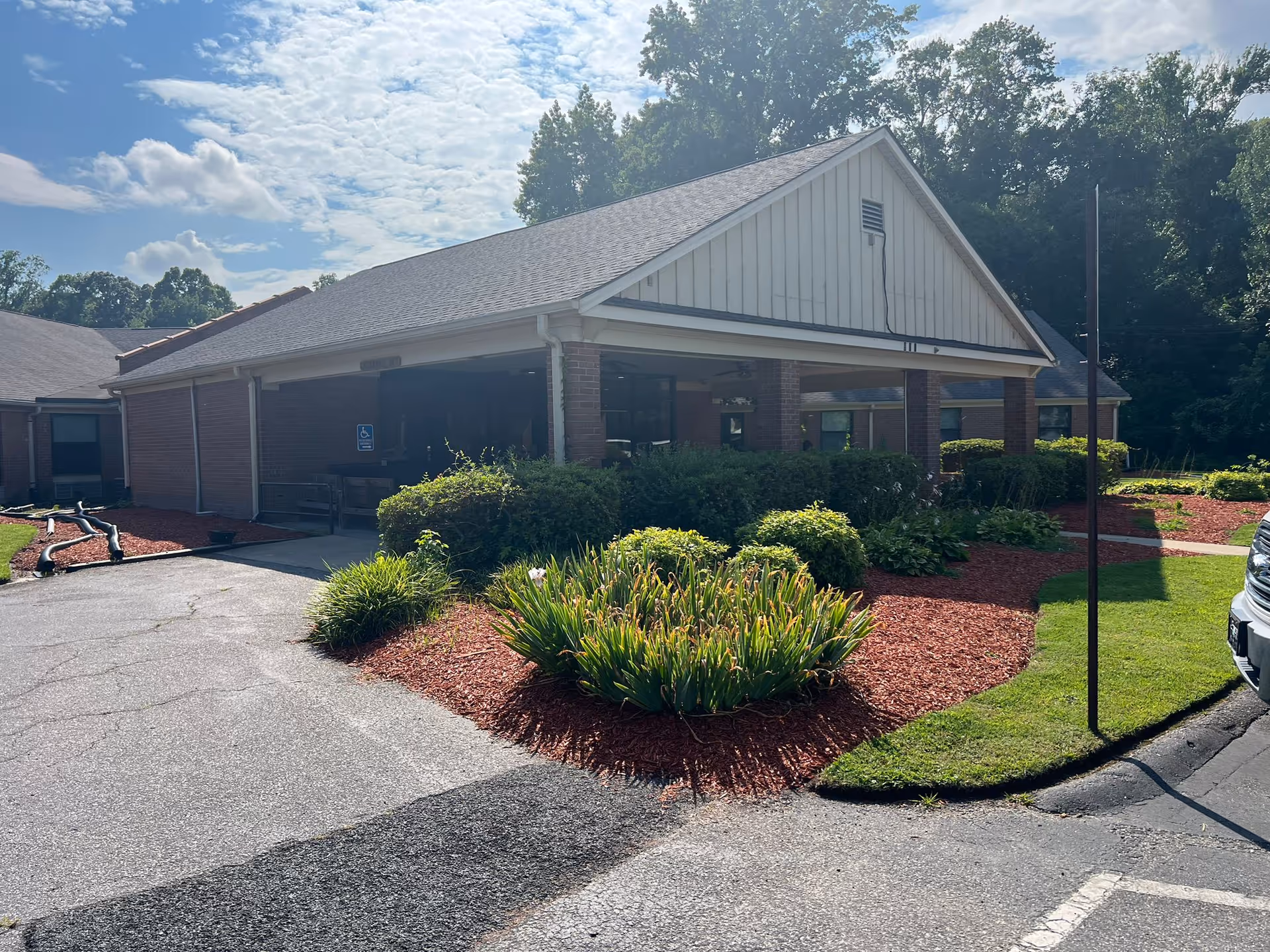 Exterior view of Laurel Park Rehabilitation & Healthcare Center entrance with landscaped shrubs.