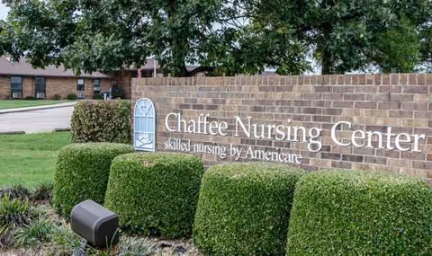Chaffee Nursing Center sign on a brick wall with trimmed hedges outside.