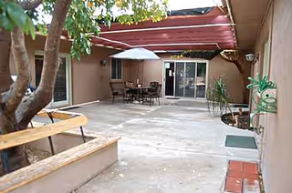 Exterior courtyard at Grovers Terrace with patio seating and sliding doors.