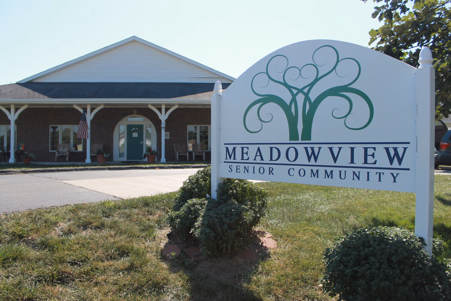 A white sign reading "Meadowview Senior Community" stands in front of a one-story brick building with a covered porch and entrance.
