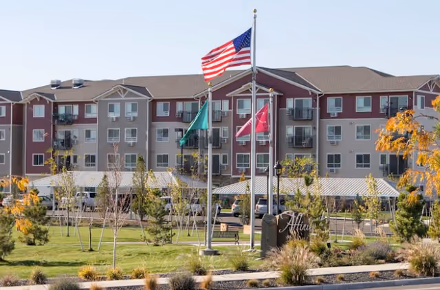 Exterior view of Affinity at Southridge building with flags and landscaped lawn