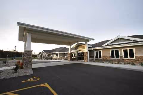 Front entrance of Eden Meadows West Green House with a covered drop-off and parking.