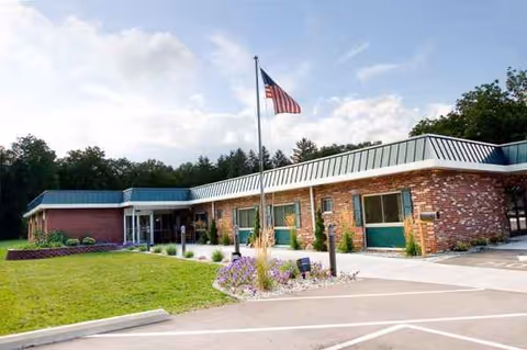 Front exterior of Life Care Center of Plainwell with flag and landscaping.