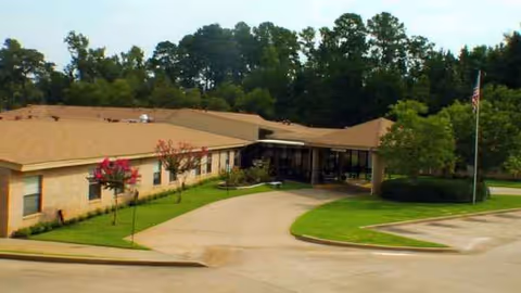 Exterior view of Willowbrook Nursing Center with a curved driveway and entrance canopy.