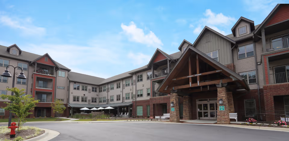 Exterior view of Harmony at Reynolds Mountain: multi-story building with a gabled entrance canopy.