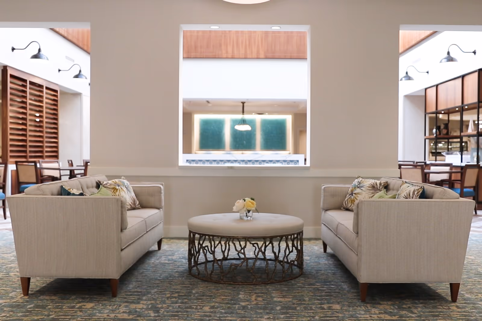 Two upholstered sofas facing each other with a round coffee table in a bright lounge area.