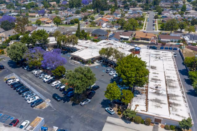 Aerial exterior view of Whittier Hills Healthcare Center with parking lot, cars, and surrounding residential neighborhood.