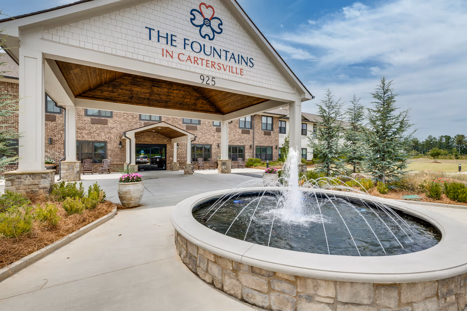 Covered porte-cochere and circular fountain at the front entrance of The Fountains in Cartersville assisted living facility.