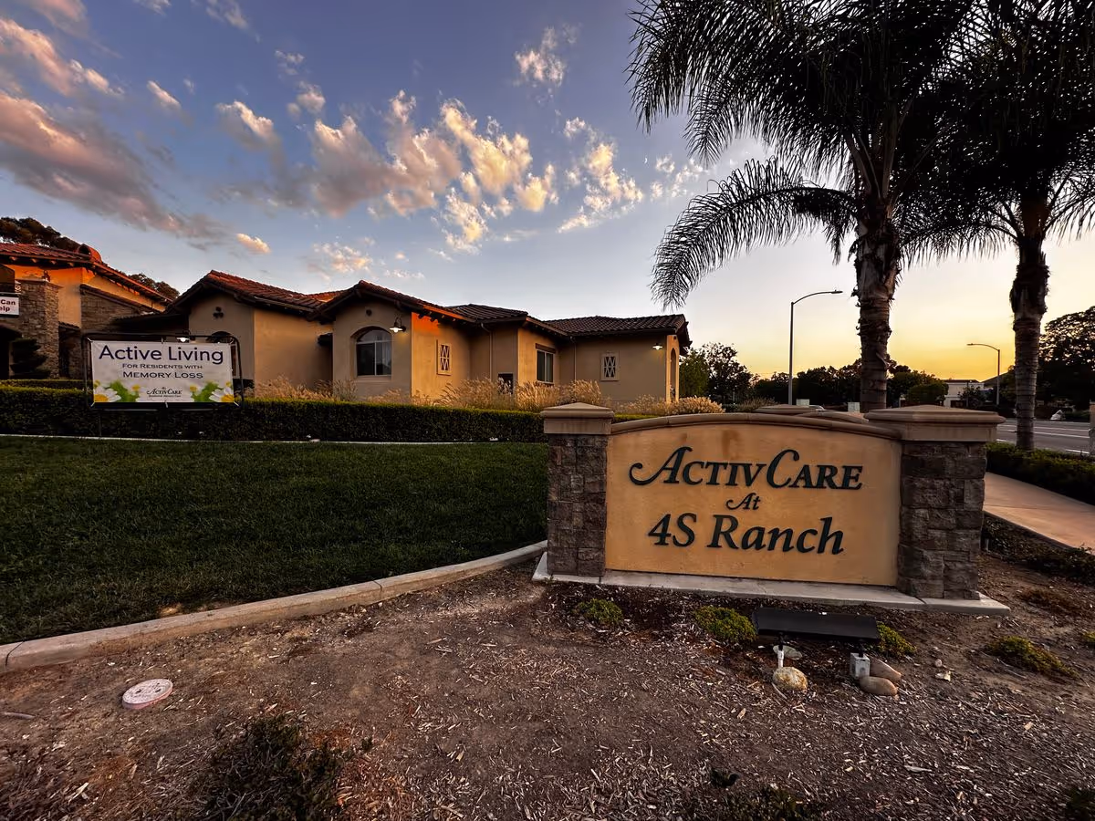 Entrance sign and front exterior of the ActivCare at 4S Ranch senior living facility at sunset.