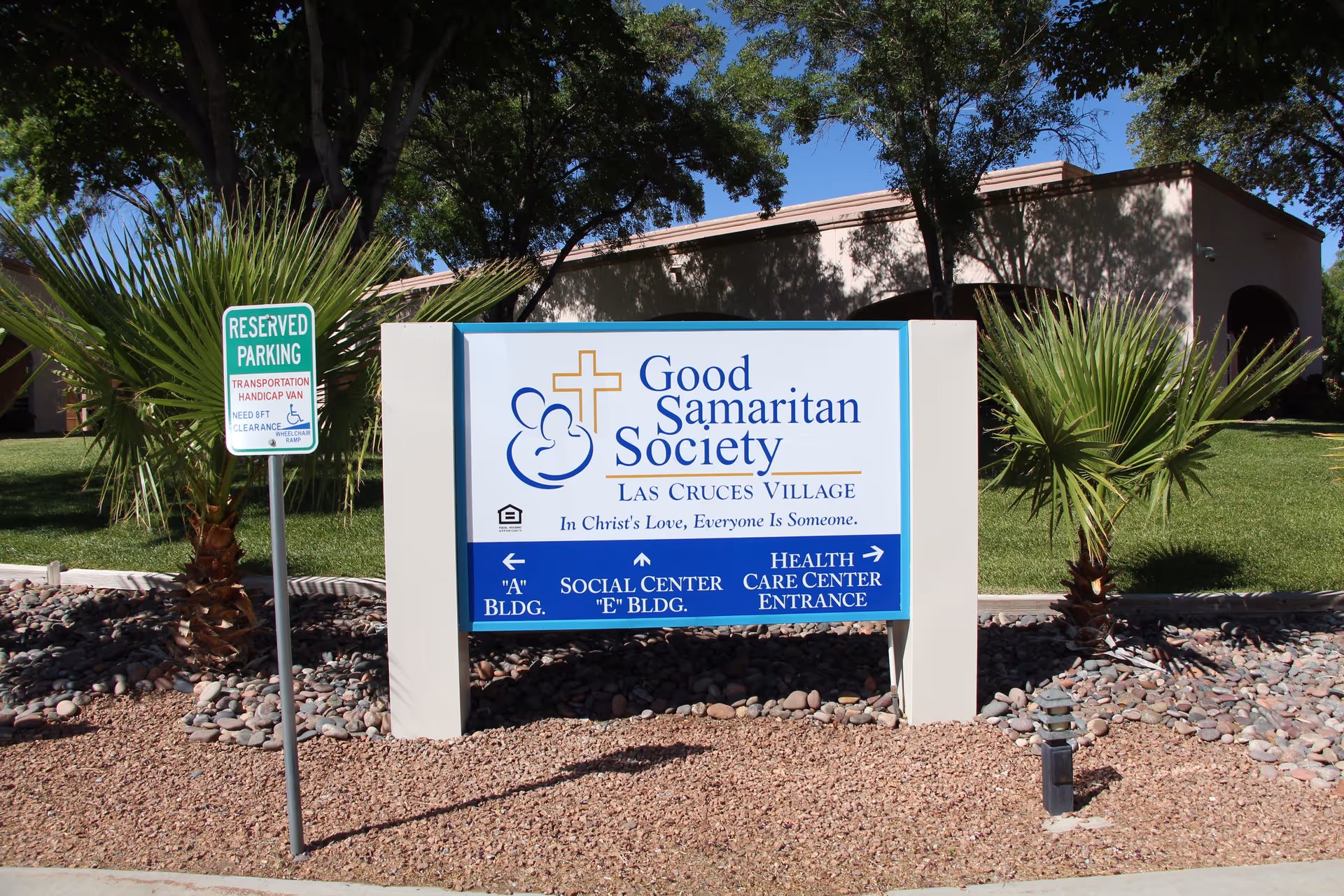 Outdoor sign for Good Samaritan Society Las Cruces Village in front of landscaped grounds and the facility building.