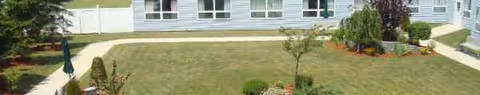 Front view of Carthage Center exterior with lawn, shrubs, and walkway.