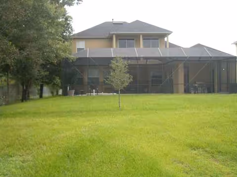 Two-story facility with a screened patio and a grassy lawn