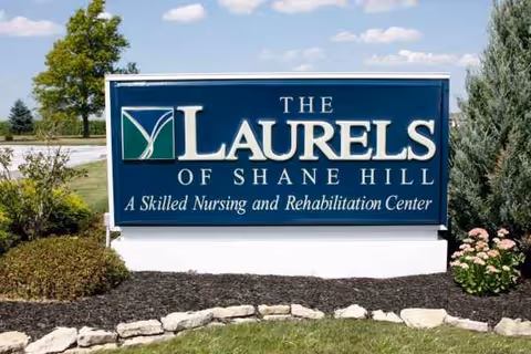 Blue sign reads The Laurels of Shane Hill, a skilled nursing and rehabilitation center.