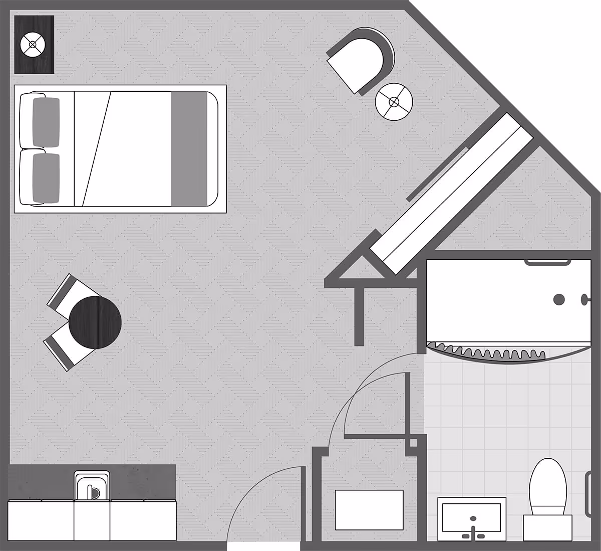 Floor plan of a senior living facility room showing a bedroom area with a bed, two pillows, a small round table with two chairs, a kitchenette with a sink, a bathroom with a toilet, sink, and shower, and a small seating area with a chair and side table.